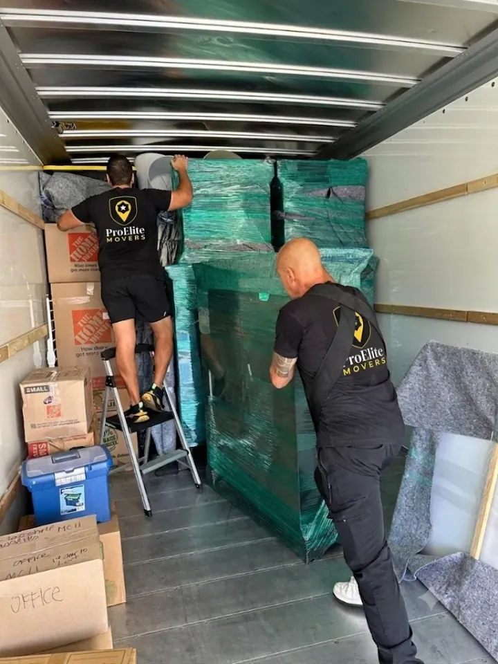 ProElite Movers crew carefully loading wrapped furniture into a truck
